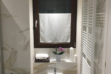 Immagine di un bagno di servizio di medie dimensioni con WC sospeso, pavimento in gres porcellanato e soffitto ribassato