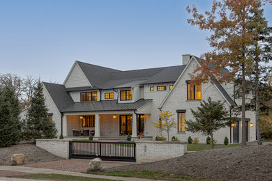 Large country yellow three-story brick and board and batten exterior home idea in Chicago with a shed roof, a shingle roof and a black roof