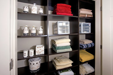 Small trendy gender-neutral reach-in closet photo in Edmonton with open cabinets and dark wood cabinets