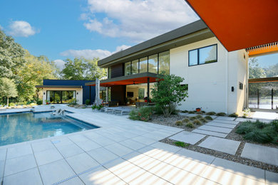 Example of a large trendy stucco exterior home design in Charlotte with a green roof and a white roof