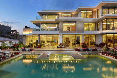 Large trendy white two-story glass exterior home photo in Toronto with a mixed material roof
