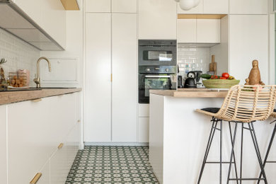パリにある高級な広い地中海スタイルのおしゃれなキッチン (インセット扉のキャビネット、白いキャビネット、木材カウンター、無垢フローリング) の写真