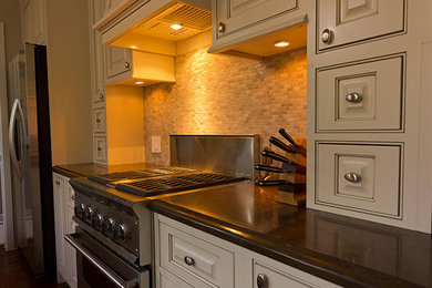 Example of a mid-sized classic l-shaped medium tone wood floor enclosed kitchen design in Chicago with an undermount sink, raised-panel cabinets, beige cabinets, quartz countertops, beige backsplash, stone tile backsplash, stainless steel appliances and no island