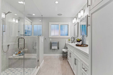 Example of a mid-sized eclectic master gray tile and ceramic tile porcelain tile, gray floor and double-sink double shower design in San Francisco with recessed-panel cabinets, white cabinets, a two-piece toilet, gray walls, an undermount sink, quartz countertops, a hinged shower door, white countertops, a niche and a built-in vanity