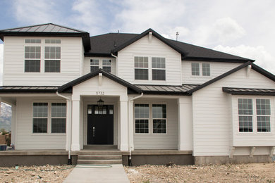 Large farmhouse white two-story concrete fiberboard house exterior photo in Salt Lake City with a shingle roof