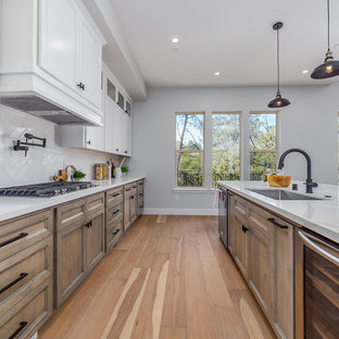 Large farmhouse kitchen pantry pictures - Inspiration for a large cottage single-wall medium tone wood floor and beige floor kitchen pantry remodel in Sacramento with an integrated sink, flat-panel cabinets, brown cabinets, granite countertops, white backsplash, ceramic backsplash, stainless steel appliances, an island and white countertops