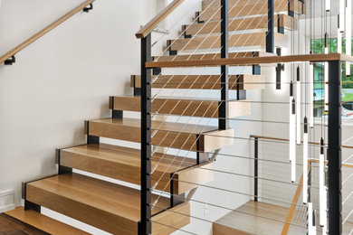 Large minimalist wooden floating open and cable railing staircase photo in New York