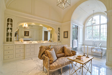 Large elegant master white tile and stone slab marble floor and white floor bathroom photo in Dallas with raised-panel cabinets, marble countertops, white cabinets, white walls, an undermount sink and a hinged shower door