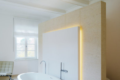 This is an example of a traditional master bathroom with a freestanding tub and beige floor.