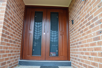 Photo of a contemporary front door in Sydney with a double front door and a dark wood front door.