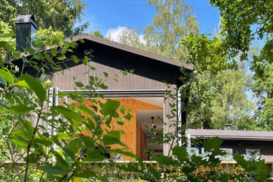 Foto på ett mellanstort skandinaviskt svart hus, med allt i ett plan och sadeltak