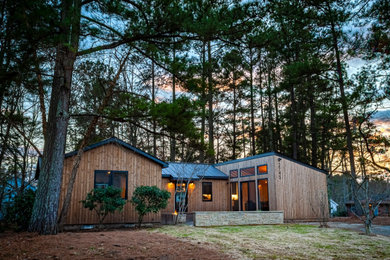 Mid-sized trendy brown one-story wood exterior home photo in Raleigh with a metal roof and a black roof