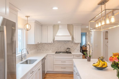 Open concept kitchen - mid-sized transitional l-shaped open concept kitchen idea in Providence with recessed-panel cabinets, white cabinets, quartz countertops, an island and white countertops