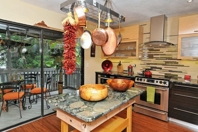 Inspiration for a small eclectic u-shaped bamboo floor and brown floor eat-in kitchen remodel in Tampa with an undermount sink, flat-panel cabinets, light wood cabinets, granite countertops, glass tile backsplash, stainless steel appliances, multicolored backsplash and an island