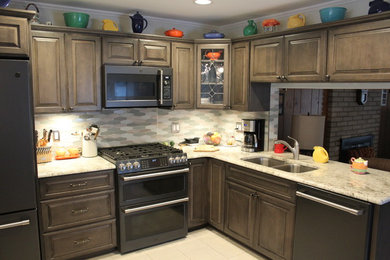 Example of a mid-sized classic l-shaped porcelain tile and gray floor eat-in kitchen design in Detroit with an undermount sink, raised-panel cabinets, medium tone wood cabinets, granite countertops, gray backsplash, mosaic tile backsplash, stainless steel appliances, a peninsula and white countertops