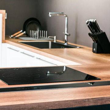 Cuisine blanc mat et noir fenix avec hotte intégrée dans un plan de travail