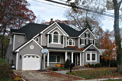 Example of a classic gray vinyl exterior home design in New York with a hip roof