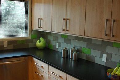 Example of a mid-sized trendy l-shaped light wood floor eat-in kitchen design in Other with an undermount sink, flat-panel cabinets, light wood cabinets, granite countertops, green backsplash, porcelain backsplash, stainless steel appliances and an island