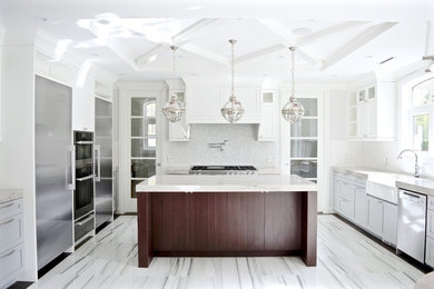 Inspiration for a large transitional u-shaped porcelain tile and multicolored floor eat-in kitchen remodel in Vancouver with a farmhouse sink, shaker cabinets, blue cabinets, limestone countertops, white backsplash, glass tile backsplash, stainless steel appliances, an island and beige countertops