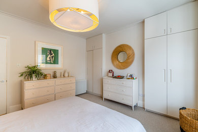 Imagen de dormitorio principal bohemio de tamaño medio con paredes blancas, moqueta y suelo gris
