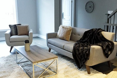 Example of a mid-sized minimalist open concept gray floor living room design in Toronto with gray walls, a hanging fireplace and no tv