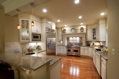 Large elegant medium tone wood floor eat-in kitchen photo in New York with an undermount sink, white cabinets, granite countertops, ceramic backsplash, stainless steel appliances and raised-panel cabinets