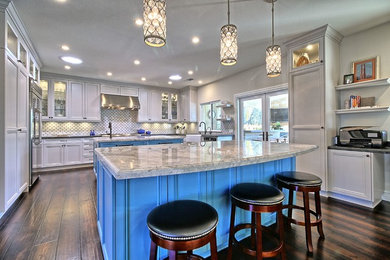 Huge transitional u-shaped medium tone wood floor and brown floor open concept kitchen photo in Los Angeles with a farmhouse sink, recessed-panel cabinets, white cabinets, quartz countertops, white backsplash, ceramic backsplash, stainless steel appliances and two islands