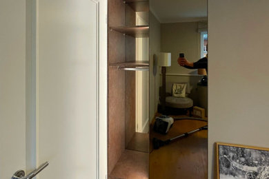 Cette image montre un petit couloir design avec un mur gris, un sol en bois brun et un sol marron.