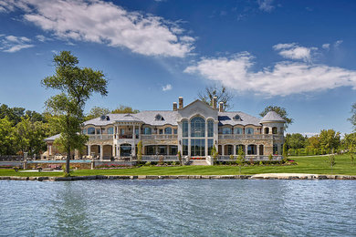 Huge elegant beige two-story stone exterior home photo in Detroit