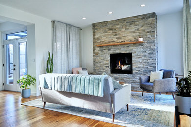 Inspiration for a medium sized classic open plan living room in Edmonton with medium hardwood flooring, a standard fireplace, a stacked stone fireplace surround, no tv and brown floors.