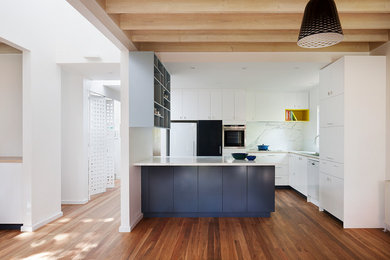 Photo of a mid-sized contemporary eat-in kitchen in Melbourne with a double-bowl sink, white cabinets, marble benchtops, white splashback, stone slab splashback, medium hardwood floors and with island.