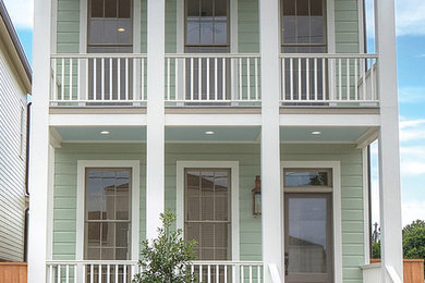 This is an example of a traditional two-storey green house exterior in New Orleans with concrete fiberboard siding and a shingle roof.