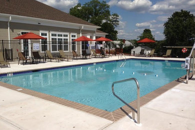 Large contemporary rectangular pool in Newark with concrete slab.