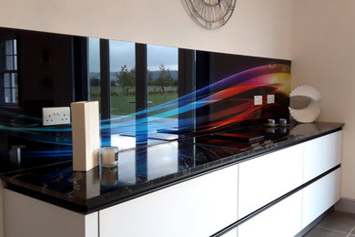 他の地域にある巨大なコンテンポラリースタイルのおしゃれなダイニングキッチン (マルチカラーのキッチンパネル、ガラス板のキッチンパネル) の写真
