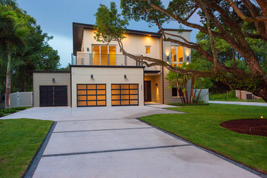 Inspiration for a large modern two-storey stucco beige exterior in Orlando with a flat roof.