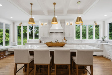 Inspiration for a huge transitional dark wood floor, brown floor and coffered ceiling eat-in kitchen remodel in Cincinnati with an undermount sink, white cabinets, quartzite countertops, white backsplash, ceramic backsplash, paneled appliances and an island