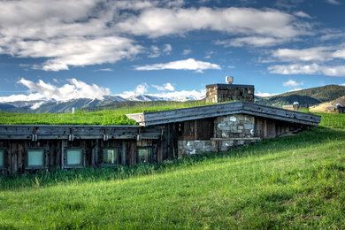 Mid-sized mountain style brown one-story mixed siding gable roof photo in Other with a green roof