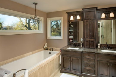 Inspiration for a timeless drop-in bathtub remodel in Columbus with an undermount sink, shaker cabinets, dark wood cabinets and beige walls