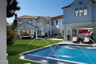 Pool fountain - large traditional backyard stone and rectangular lap pool fountain idea in Orange County