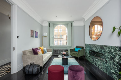 На фото: большая парадная, открытая гостиная комната в современном стиле с серыми стенами, темным паркетным полом, горизонтальным камином, фасадом камина из камня и черным полом без телевизора с