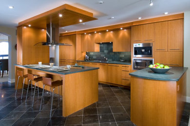 Inspiration for a large contemporary l-shaped eat-in kitchen in Other with an undermount sink, flat-panel cabinets, light wood cabinets, blue splashback, stainless steel appliances, marble floors, with island, subway tile splashback and black floor.