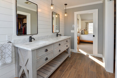 Alcove shower - huge coastal master multicolored tile and ceramic tile medium tone wood floor and brown floor alcove shower idea in New York with furniture-like cabinets, light wood cabinets, a one-piece toilet, white walls, an undermount sink, quartz countertops and a hinged shower door
