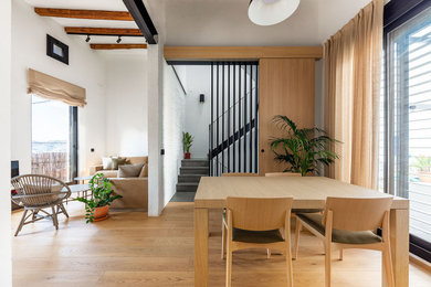 Пример оригинального дизайна: гостиная-столовая среднего размера в скандинавском стиле с белыми стенами, светлым паркетным полом и балками на потолке