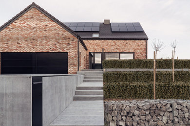Idée de décoration pour un porche d'entrée de maison design avec des pavés en brique.