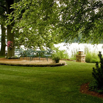 Elliptical sandstone terrace floating in the lawn & built around an existing tre