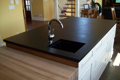 Inspiration for a mid-sized craftsman l-shaped gray floor eat-in kitchen remodel in Other with an undermount sink, raised-panel cabinets, soapstone countertops, slate backsplash, black appliances, an island and white cabinets