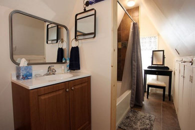 Example of a mid-sized 1960s brown tile and stone tile slate floor, brown floor and single-sink bathroom design in Denver with furniture-like cabinets, brown cabinets, white walls, an integrated sink, solid surface countertops, white countertops and a niche