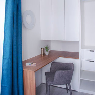 Inspiration for a medium sized modern study in Paris with white walls, lino flooring, a corner fireplace, a stone fireplace surround, a built-in desk and grey floors.