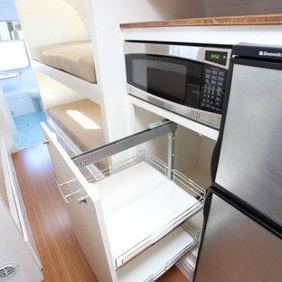 Small contemporary kitchen pantry pictures - Kitchen pantry - small contemporary galley bamboo floor kitchen pantry idea in Santa Barbara with a double-bowl sink, flat-panel cabinets, gray cabinets, wood countertops, blue backsplash, glass tile backsplash and stainless steel appliances