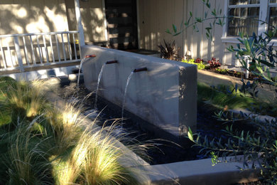 Photo of a mid-sized farmhouse drought-tolerant courtyard gravel water fountain landscape in Orange County.
